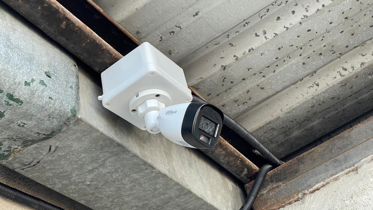 Cámara de seguridad Dahua montada bajo el techo metálico, vigilando el complejo de bodegas.